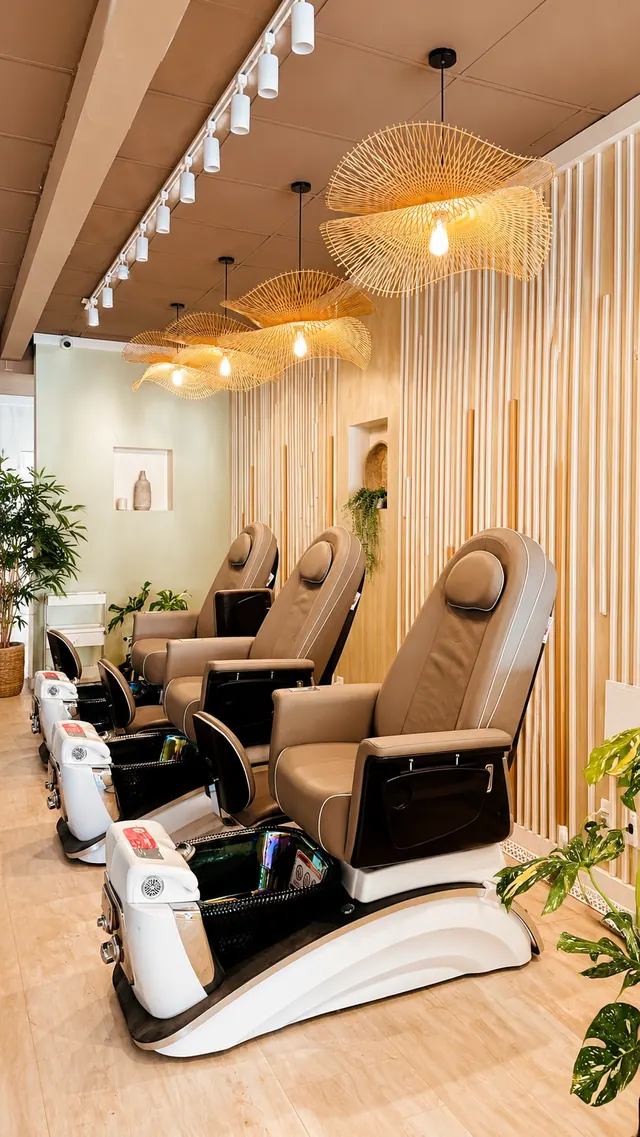 The Zenvie lounge — plush caramel chairs beneath woven rattan pendants beside a pale oak slat wall